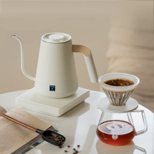 Bollitore elettrico bianco con beccuccio stretto e dettaglio in legno per versare con precisione nella preparazione del caffè, tutto sul caffè.