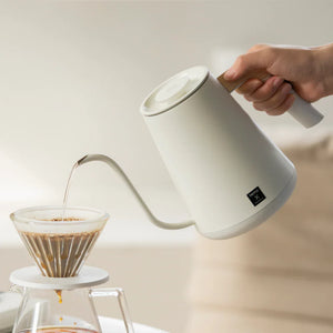 Bollitore elettrico bianco con beccuccio stretto e manico in legno per precisione nella preparazione del caffè di Timemore, tutto sul caffè.